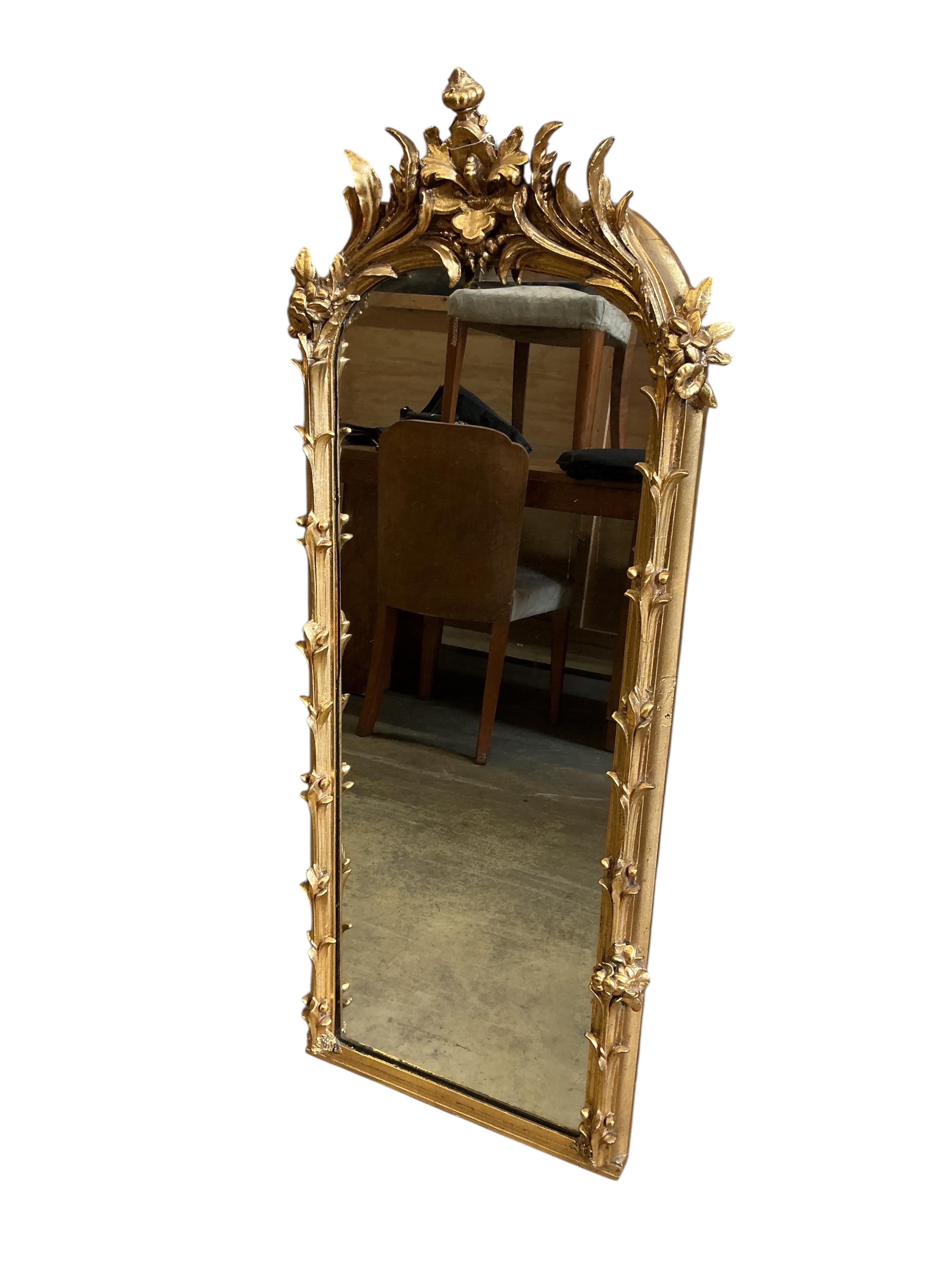 A 19th century carved giltwood and composition wall mirror, re-guilded, width 48cm, height 126cm